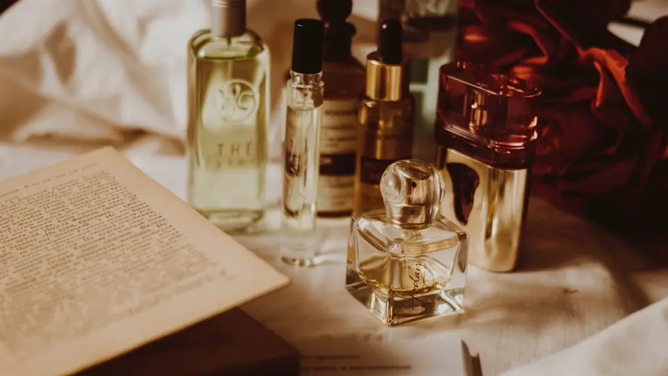 Livre ouvert entouré de flacons de parfum